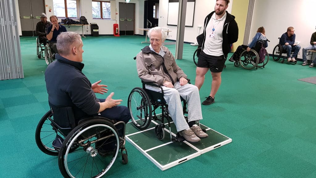 Wheelchair skills trainer teaching a new technique to a participant