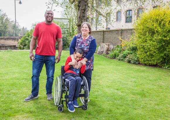 A family with a young boy with a spinal cord injury in a garden