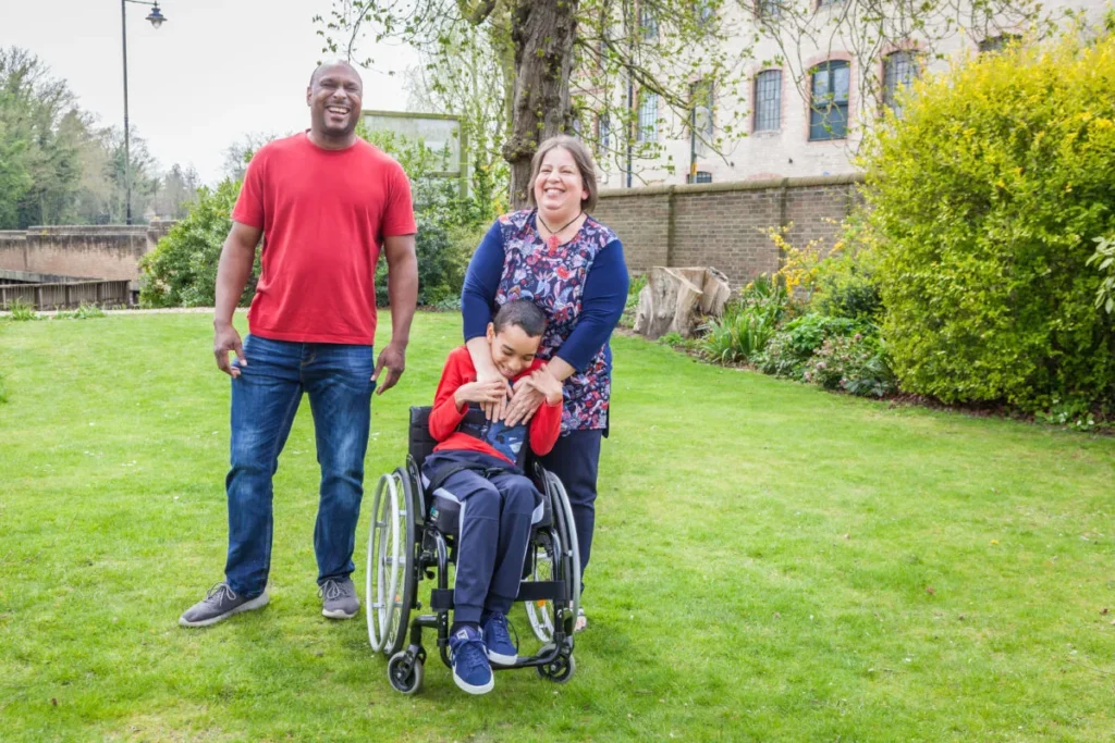 A family with a young boy with a spinal cord injury in a garden