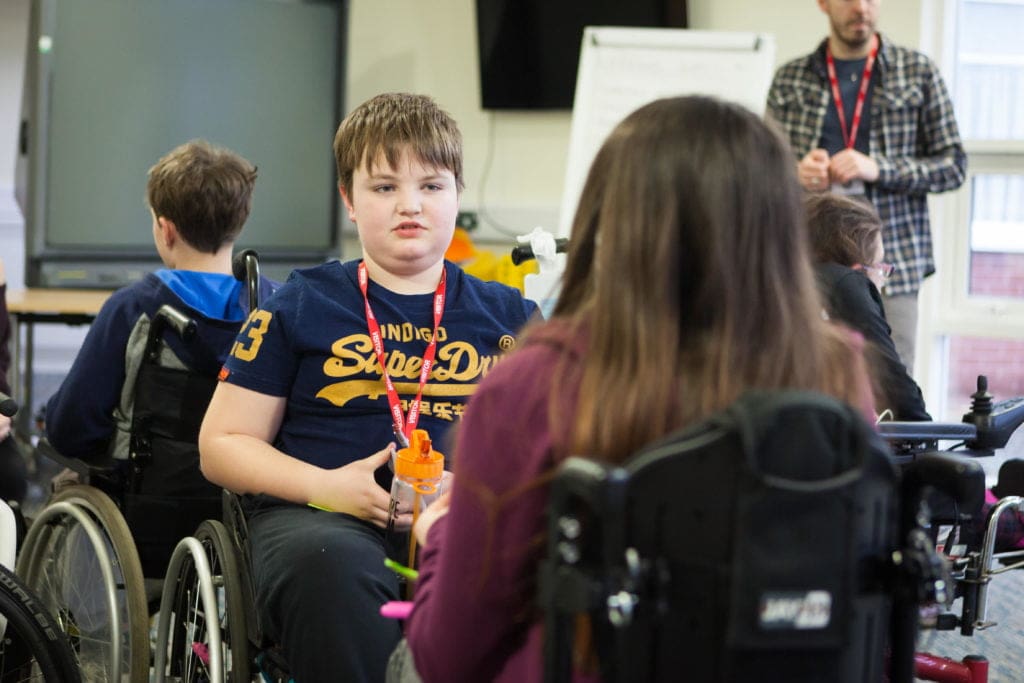 Young wheelchair users having a discussion at a training weekend