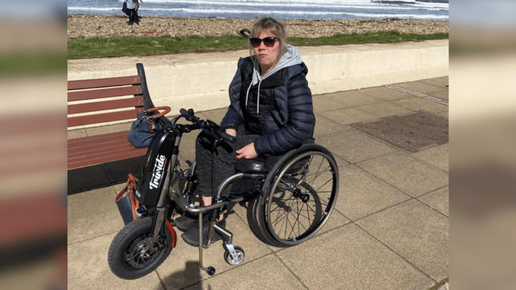 A wheelchair user by the coast - back up was there to help her get back to work after spinal cord injury