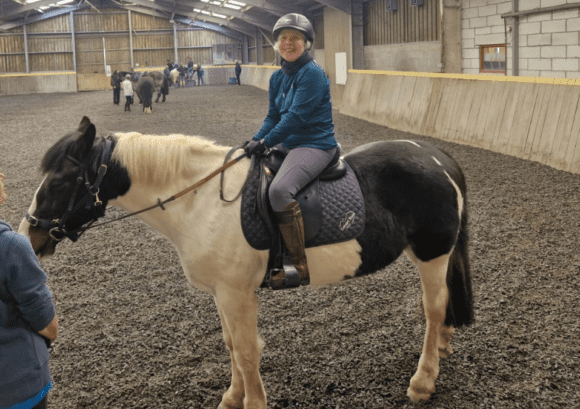 Tina, who back up helped with independence after spinal cord injury, riding a horse on one of our multi activity courses