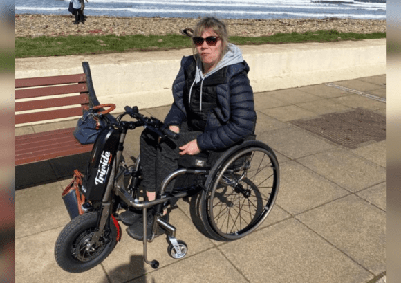 A wheelchair user by the coast - back up was there to help her get back to work after spinal cord injury