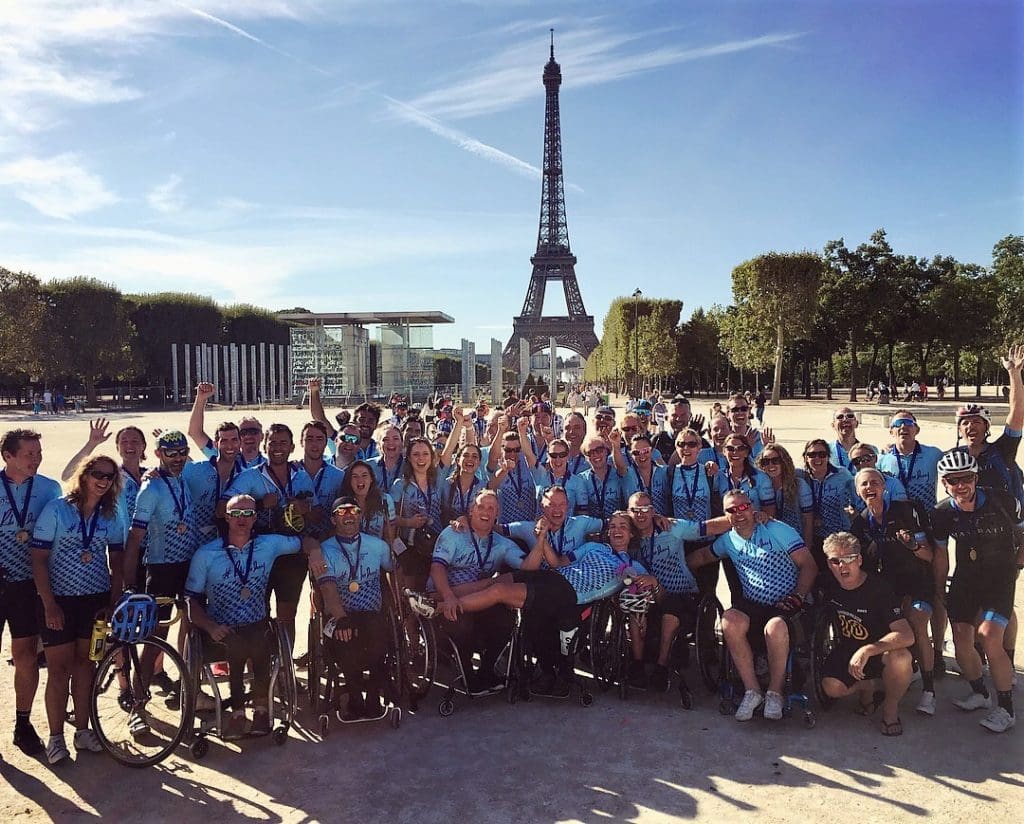 The triumphant London to Paris team pose in front of the Eiffel Tower after finishing the ride