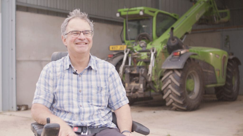 James with his tractor on returning to work confidently after a spinal cord injury