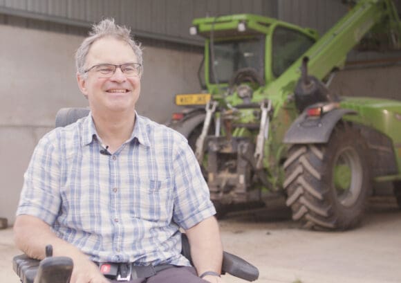 James with his tractor on returning to work confidently after a spinal cord injury