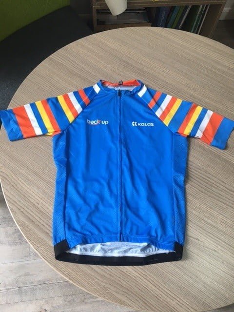 Front of a blue #NoLimits cycling jersey with stripes on the sleeves