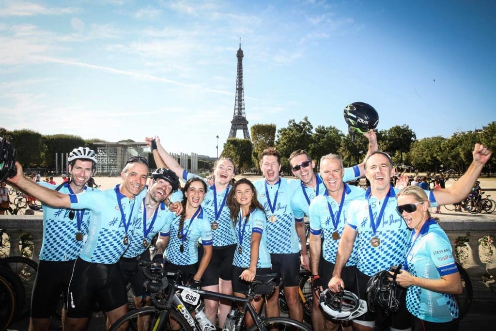 A group of our London to Paris cyclists celebrating reaching the finish line of the cycling challenge.