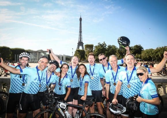 A group of our London to Paris cyclists celebrating reaching the finish line of the cycling challenge.