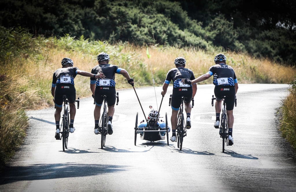 Four cyclists and a hand cyclist make their way along a road during our #RideforDanny cycling challenge.