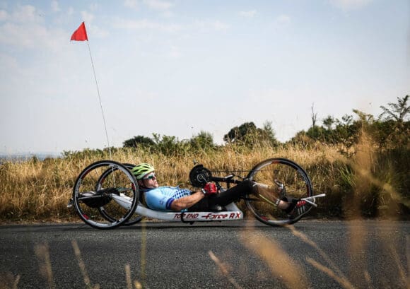 Ian hand cycling on a country road for our vital services