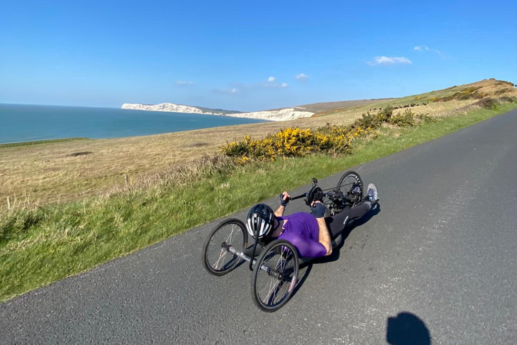 Ollie Thorn handcycling by some white cliffs