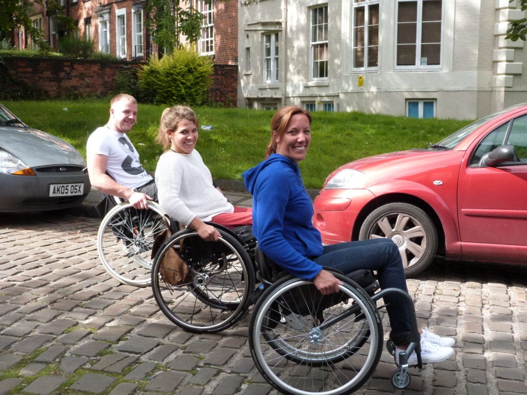 Three wheelchair users on a course