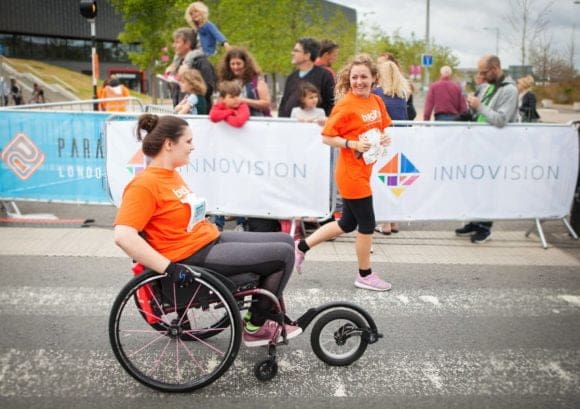 Wheelchair user and runner corss the line together at Parallel London