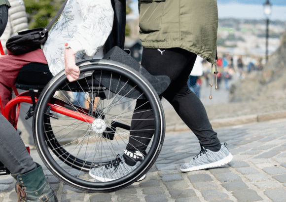 a wheelchair user tackling a hill with support from an assistant on one of our courses