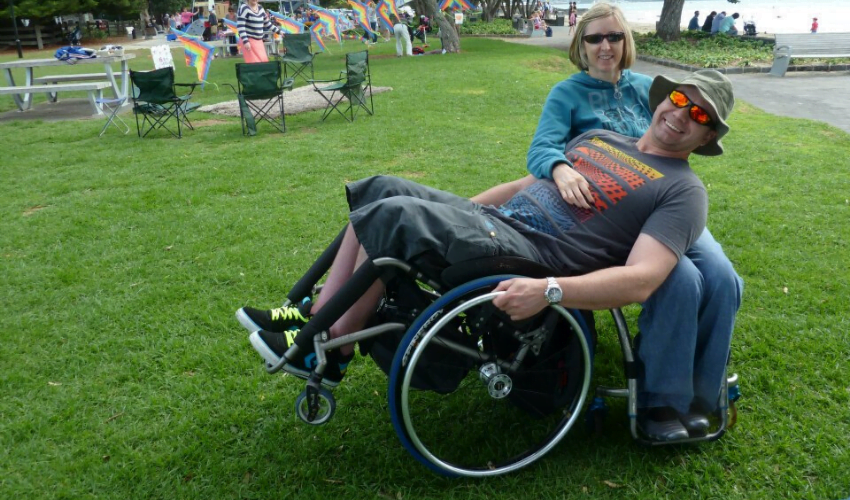 Jacques, someone with an incomplete spinal cord injury who uses a manual wheelchair, on holiday with his wife