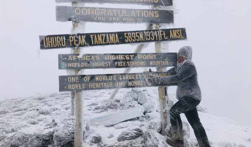 Sophie at the summit after climbing kilimanjaro with a spinal cord injury 