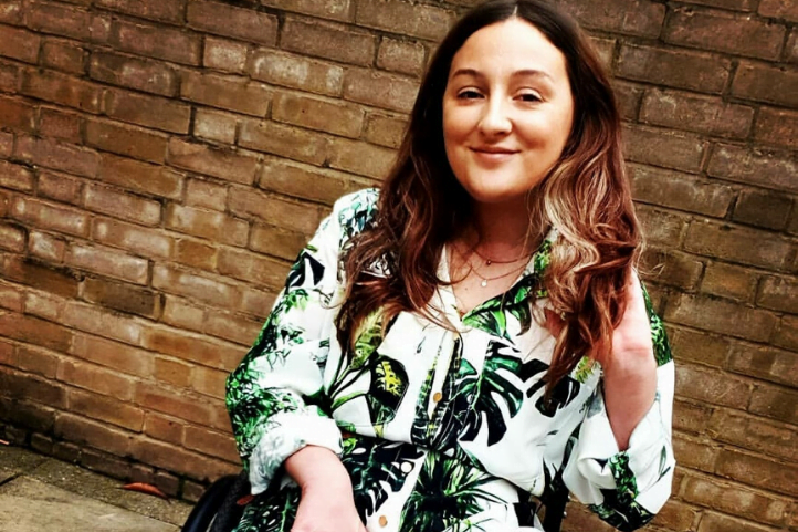 Emma @Sittingdownstyle posing in front of a brick wall