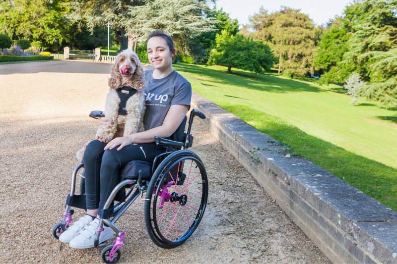 A young wheelchair user and her dog