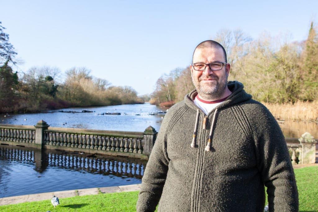 Richard, one of our family mentor volunteers, stood by a lake on a sunny day