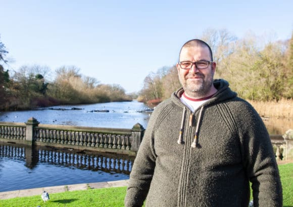 Richard, one of our family mentor volunteers, stood by a lake on a sunny day