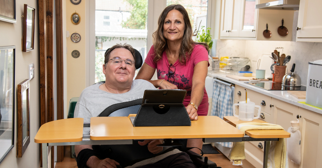 A wheelchair user and his sister pose for a photo - discover how you can support Back Up as a spinal cord injury mentor or family mentor