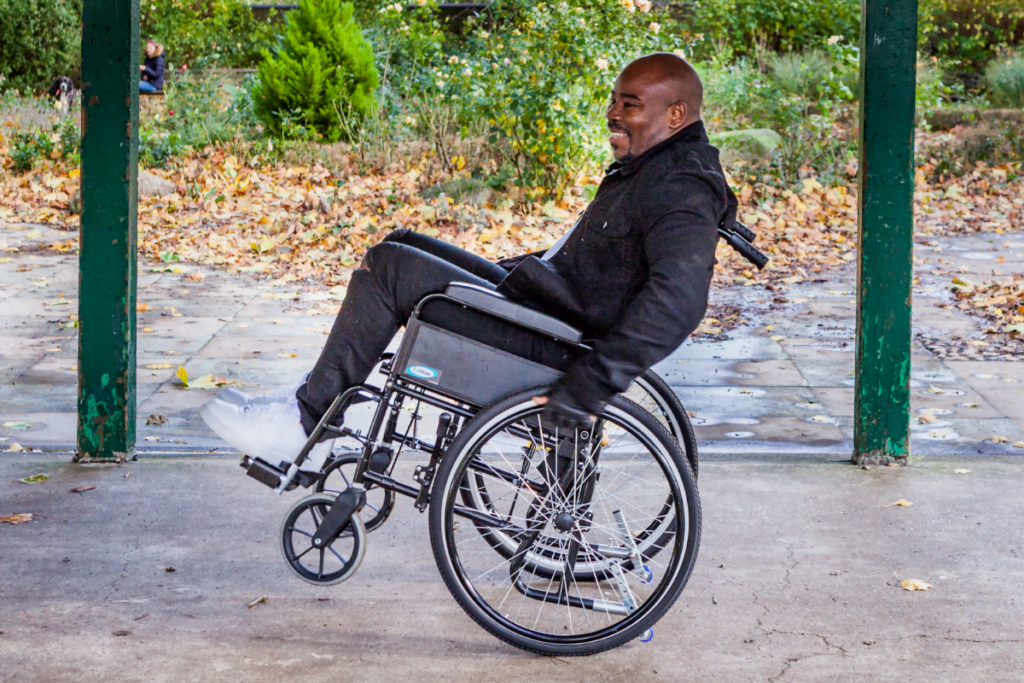 a wheelchair user practicing a back wheel balance. "What Next?" can help you live well after spinal cord injury.