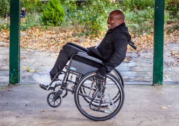 a wheelchair user practicing a back wheel balance. "What Next?" can help you live well after spinal cord injury.