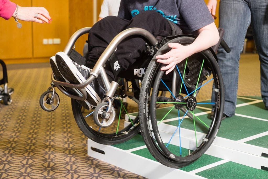 Wheelchair user going down a kerb during a skills session