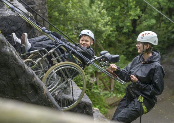 Young wheelchair user and volunteer abseiling