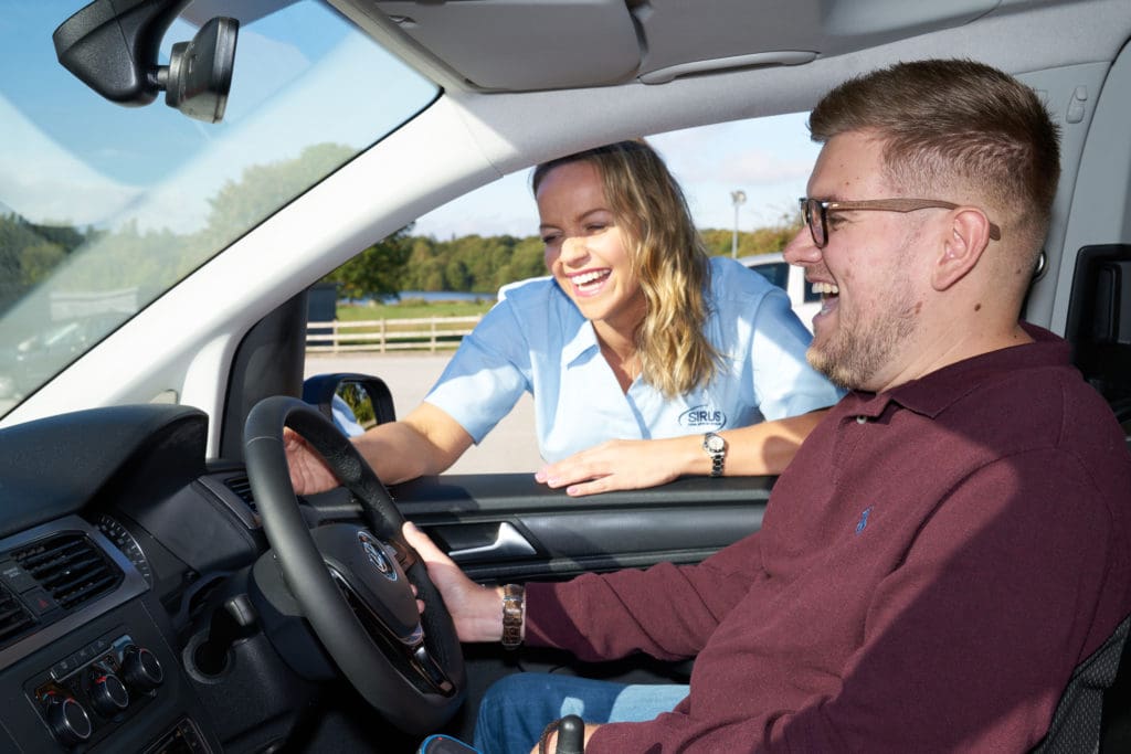 Chris being shown by Tina how to use his car adaptations to drive independently